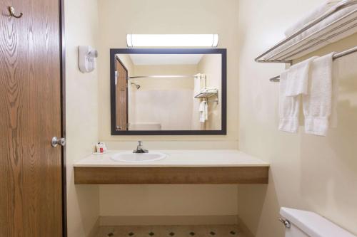 a bathroom with a sink and a mirror at Super 8 by Wyndham Eau Claire I-94 in Eau Claire