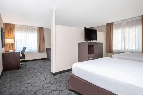 une chambre d'hôtel avec un lit et une télévision à écran plat dans l'établissement Baymont by Wyndham San Diego Downtown, à San Diego