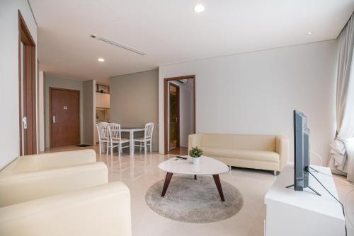 a living room with a tv and a table at The Penthouse KLCC in Kuala Lumpur