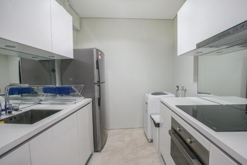 a white kitchen with a sink and a dishwasher at The Penthouse KLCC in Kuala Lumpur