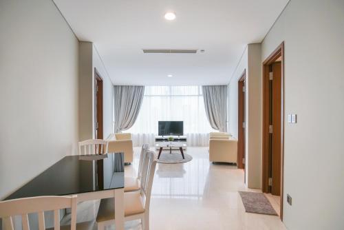 a living room with a table and chairs and a television at The Penthouse KLCC in Kuala Lumpur