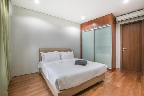 a bedroom with a white bed and a sliding glass door at The Penthouse KLCC in Kuala Lumpur