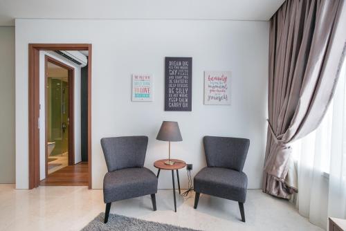 two chairs and a table and a lamp in a room at The Penthouse KLCC in Kuala Lumpur