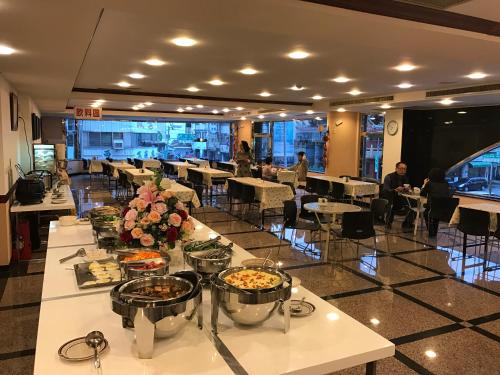 a restaurant with tables and people sitting at tables at Sunrise Hotel in Tainan