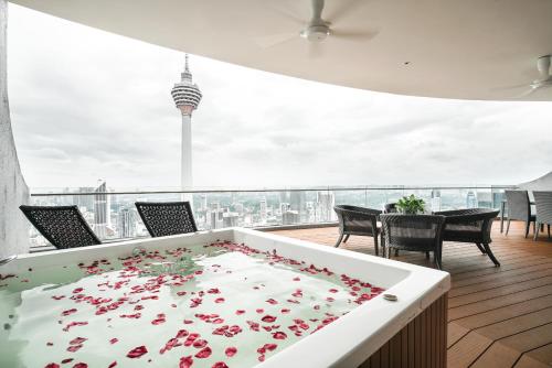 a large white table with flowers on it on a balcony at The Penthouse KLCC in Kuala Lumpur
