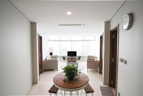 a living room with a table and a tv at The Penthouse KLCC in Kuala Lumpur