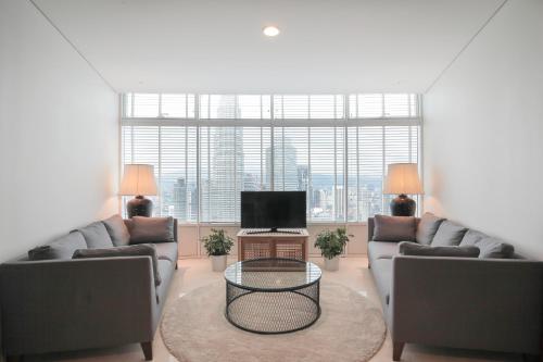 a living room with two couches and a television at The Penthouse KLCC in Kuala Lumpur