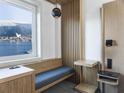 a room with a window and a blue bench with a windowseat at Radisson Blu Hotel Tromsø in Tromsø