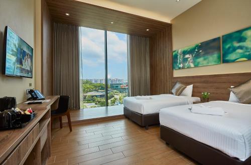 a hotel room with two beds and a large window at D'Resort @ Downtown East in Singapore