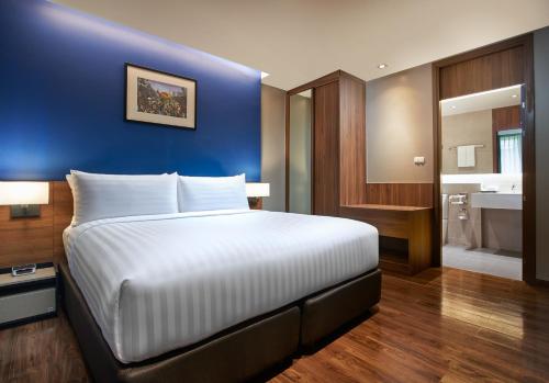 a bedroom with a large bed and a blue wall at Amp Am House Bangkok Hotel in Bangkok