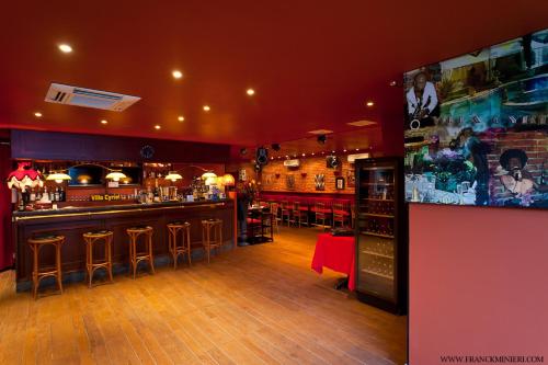 a bar with bar stools and a tv in a room at Villa Cyriel in Contes