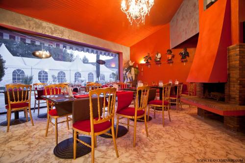 a dining room with tables and chairs and a fireplace at Villa Cyriel in Contes