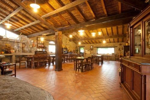 a restaurant with wooden tables and chairs in a room at Agriturismo Testone in Benetutti