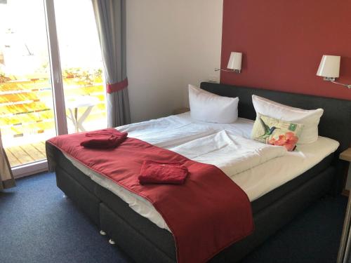 a bedroom with a large bed with a red wall at Hotel Zum Mühlental in Buch