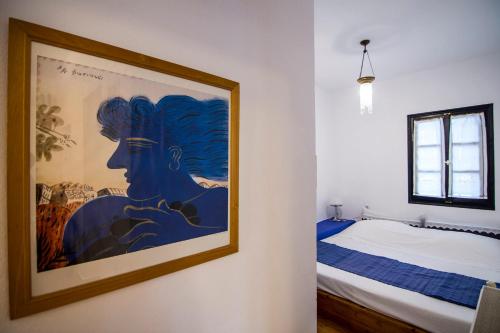 a painting of a woman on a wall next to a bed at Dreaming House in Nea Vrasna