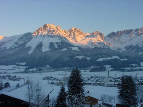 a snow covered mountain with a town in front of it at Haus Anne in Ellmau