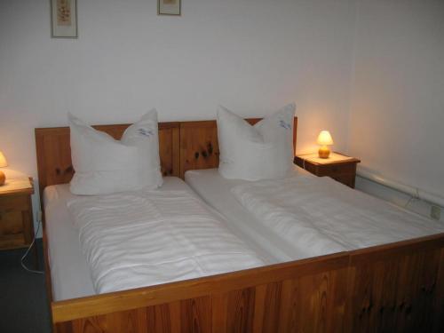 a bed with white sheets and pillows on it at Haus Anne in Ellmau