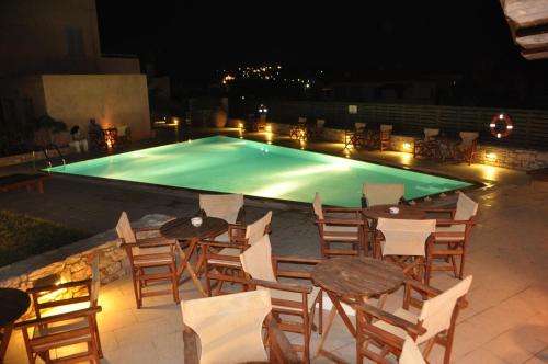 a pool with tables and chairs in front of it at Petradi in Livadi