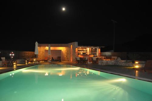 a large swimming pool at night with the moon at Petradi in Livadi