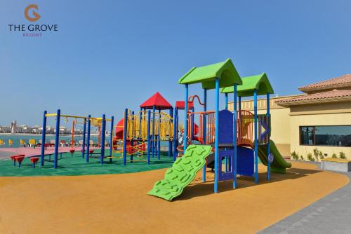 a child is standing in front of a playground at The Grove Resort Bahrain in Manama