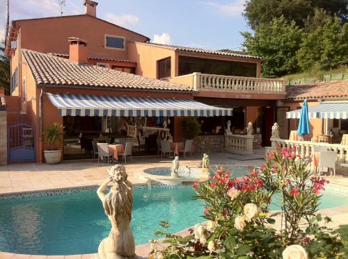 uma piscina com uma estátua em frente a uma casa em Villa Cyriel em Contes