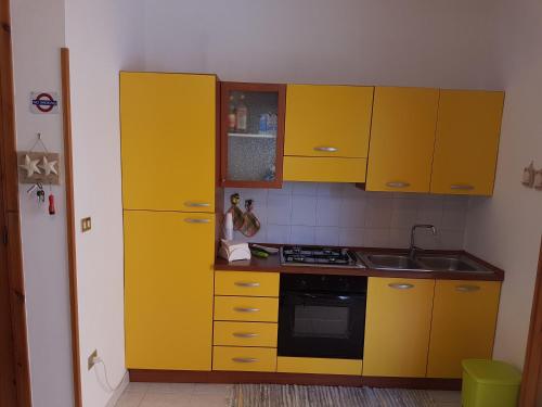 una cucina con armadi gialli e lavandino di Tower of the Bear Flat a Torre dell'Orso
