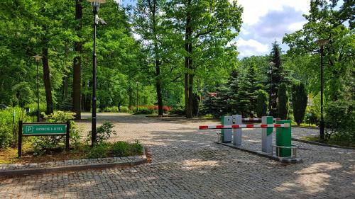 a path in a park with a street sign and trees at Stacja Nowa Gdynia Bed & Breakfast Aquapark in Łódź