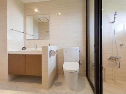 a bathroom with a toilet and a sink and a shower at ホテルコンドミニアム土花土花 in Onna