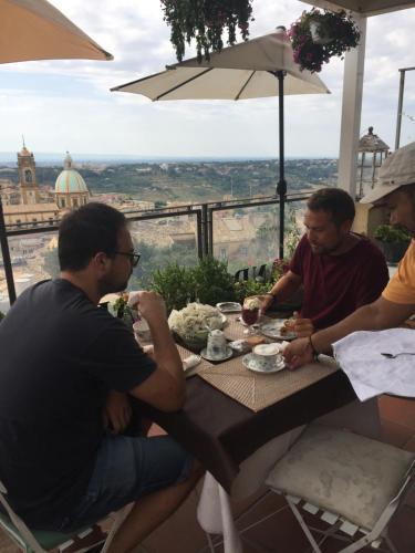 a group of men sitting at a table eating food at Casa tipica siciliana patronale home BedandBreakfast TreMetriSoprailCielo Camere con vista, colazione interna in terrazzo panoramico in Caltagirone