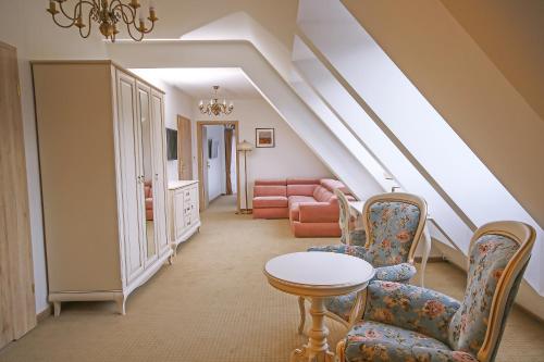 a living room with chairs and a table and a couch at Hotel Paryski Art & Business Zakopane - Basen Jacuzzi Sauna Małpi Gaj in Zakopane