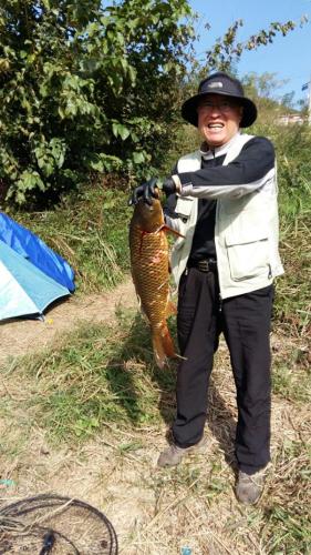 a boy holding a fish in his hand at Heidi Korea in Hongcheon