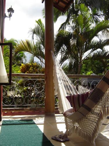 a person sitting in a hammock on a porch at Pousada Preamare in Ubatuba
