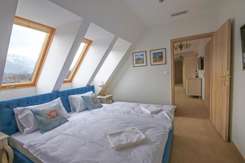 a bedroom with a large bed with white sheets and pillows at Hotel Paryski Art & Business Zakopane - Basen Jacuzzi Sauna Małpi Gaj in Zakopane
