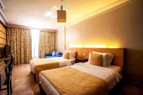 a hotel room with two beds and a television at Lahoya Beirut in Beirut