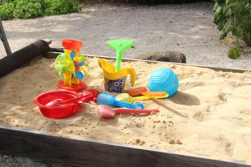 a sandbox filled with toys in the sand at Casa o Futuro in Alcobaça