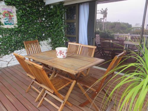 a wooden table and chairs on a deck at Rose and Ale Self Catering Units in Gonubie