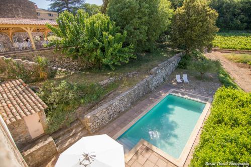 - une vue sur la piscine dans une cour arborée dans l'établissement Le Lodge du Domaine Saint Martin, à Flassans-sur-Issole