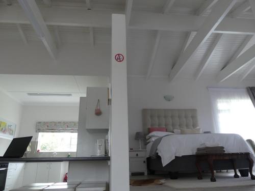 a bedroom with a bed in a white room at Rose and Ale Self Catering Units in Gonubie