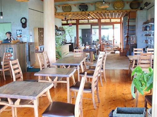 a restaurant with wooden tables and chairs in a room at ホテルコンドミニアム土花土花 in Onna