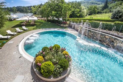 a swimming pool with a fountain in a yard at Hotel Miramonti in Bagno di Romagna
