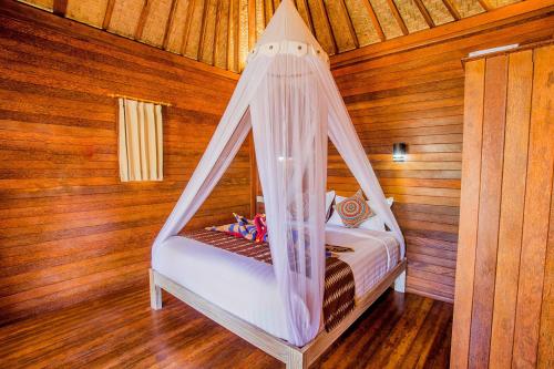 a bedroom with a bed with a mosquito net at Sea Bridge Villa Ceningan in Nusa Lembongan