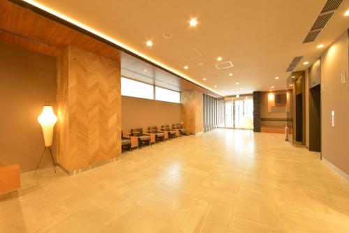 a large lobby with a waiting room with chairs at Dormy Inn Takamatsu Chuo Koenmae Natural Hot Spring in Takamatsu