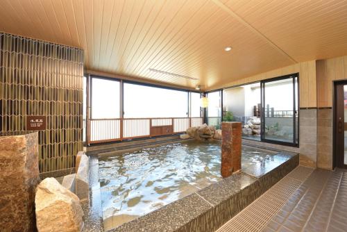 a large indoor swimming pool in a room with windows at Dormy Inn Takamatsu Chuo Koenmae Natural Hot Spring in Takamatsu