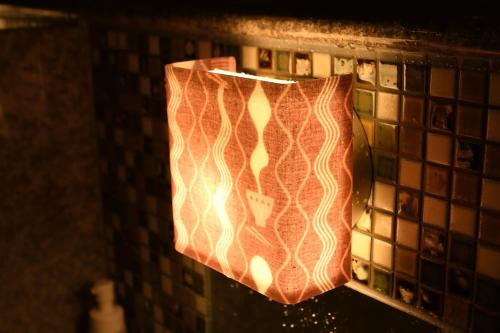 a light hanging from a wall in a bathroom at Dormy Inn Takamatsu Chuo Koenmae Natural Hot Spring in Takamatsu