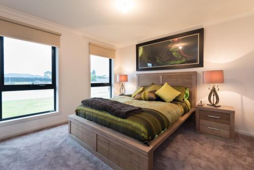 a bedroom with a large bed and two windows at Euphoria House in Wynyard