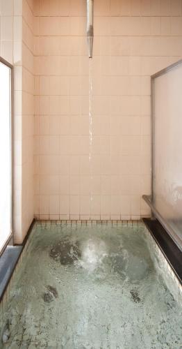 a pool of water in a tiled room with at Subaruyado Yoshino in Tokushima