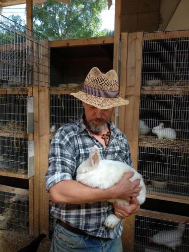 a man wearing a cowboy hat holding a white rabbit at Rodinné vinařství Mikulenkovi in Žernoseky