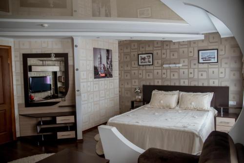 a bedroom with a bed and a tv in it at Dniprovski Zori in Kremenchuk