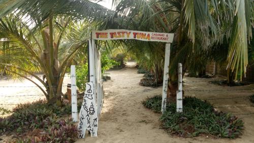 a sign that says the fish triathlon on a beach at The Tasty Tuna Cabana in Arugam Bay
