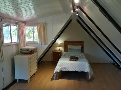 um quarto com uma cama num sótão em Masescha Country Estate em Plettenberg Bay